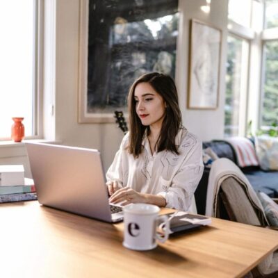 A woman working on her laptop in her home office.