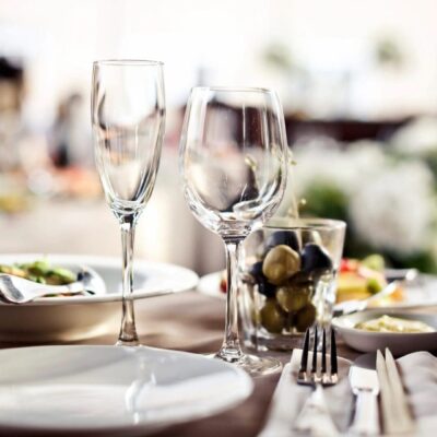 A table setting with wine glasses, plates and silverware.