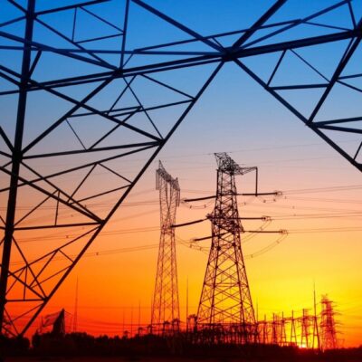 High voltage power lines at sunset stock photo.