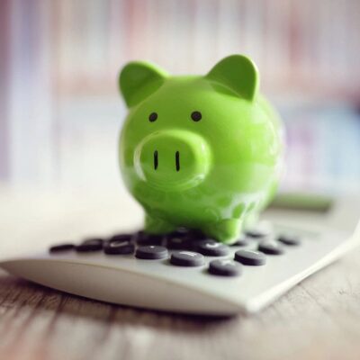 Green piggy bank on a calculator.