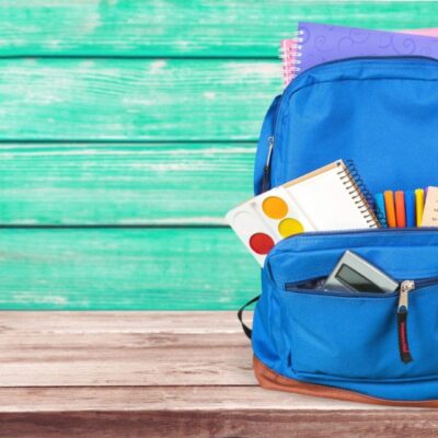Blue backpack filled with school supplies.