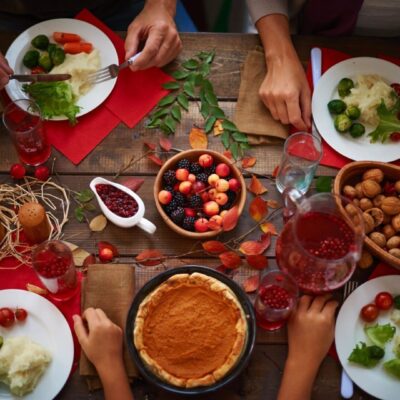 A group of people sitting around a table eating thanksgiving dinner.
