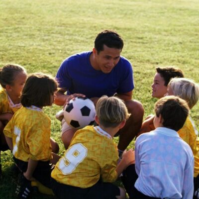 Soccer coach instructing young players.