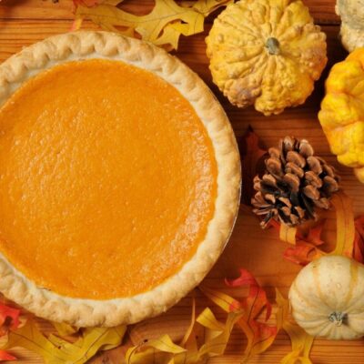 Sweet potato pie surrounded by autumn leaves.