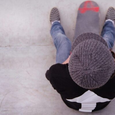 A person sitting on a skateboard.