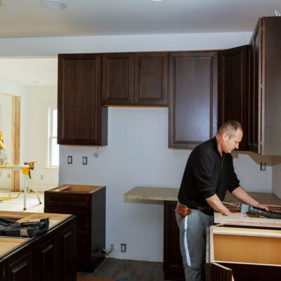 A man is working in a kitchen that is being remodeled.