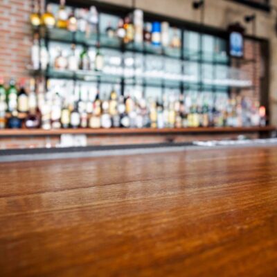 A wooden bar with bottles on it in a restaurant.