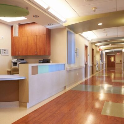 A hallway in a hospital with wooden floors.