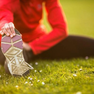 Runner stretching on the grass.
