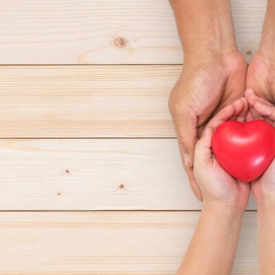 Hands holding a red heart.