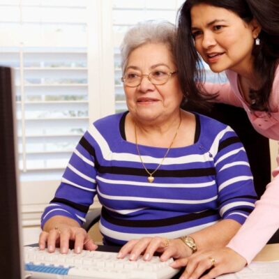 A woman and an older woman working on a computer.