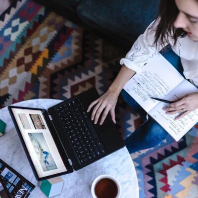 A woman working on a laptop in a living room.