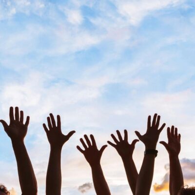 A group of people raising their hands up to the sky.