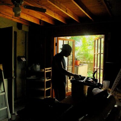 Silhouetted person working in a dark room.