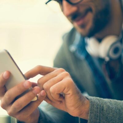 Man using smartphone, close-up.