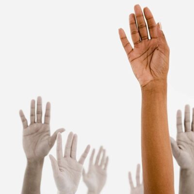 A group of people raising their hands in the air.