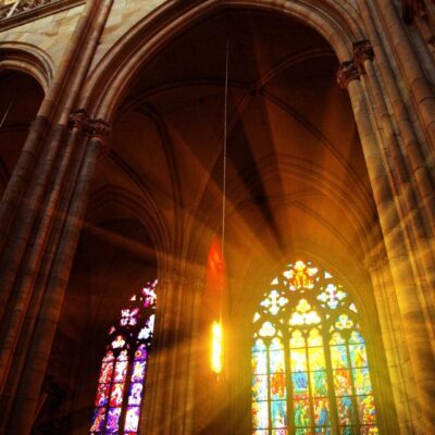 The sun is shining through a window in a cathedral.