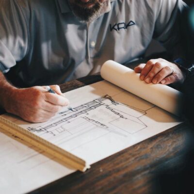 A man working on a blueprint at a table.