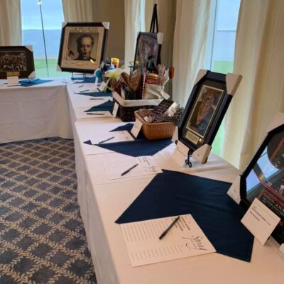 An auction table with a variety of framed pictures.