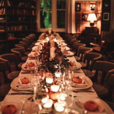 A long table set with candles and pumpkins.