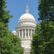 A white building with trees in front of it.