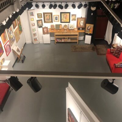 An aerial view of an art gallery with a red couch.